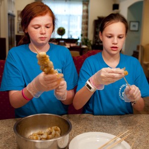 Threading shrimp on skewers. Image by CaseyBoonePhotography.com. All rights reserved